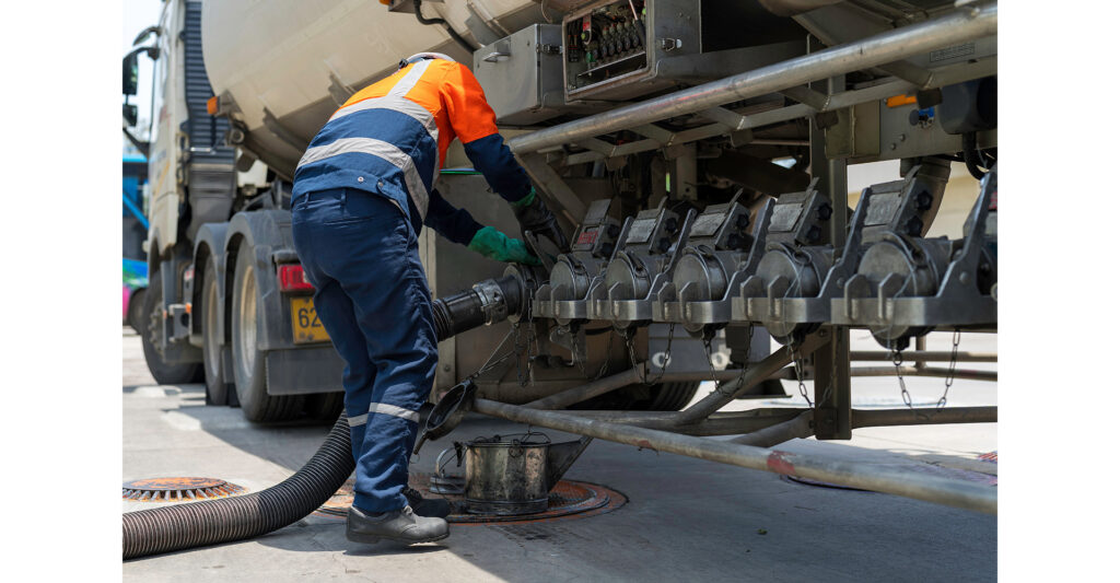 Road Tanker Offloading Human Factors: A tanker driver connecting a hose to the connection points of the truck