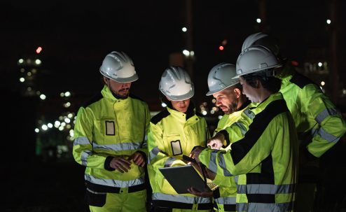 Are we collecting data or are we learning? Workers look over plans together.