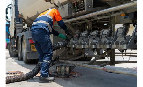 Road Tanker Offloading Human Factors: A tanker driver connecting a hose to the connection points of the truck